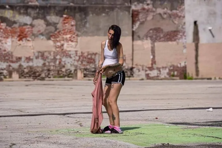 Una ragazza incinta seduta sul marciapiede
